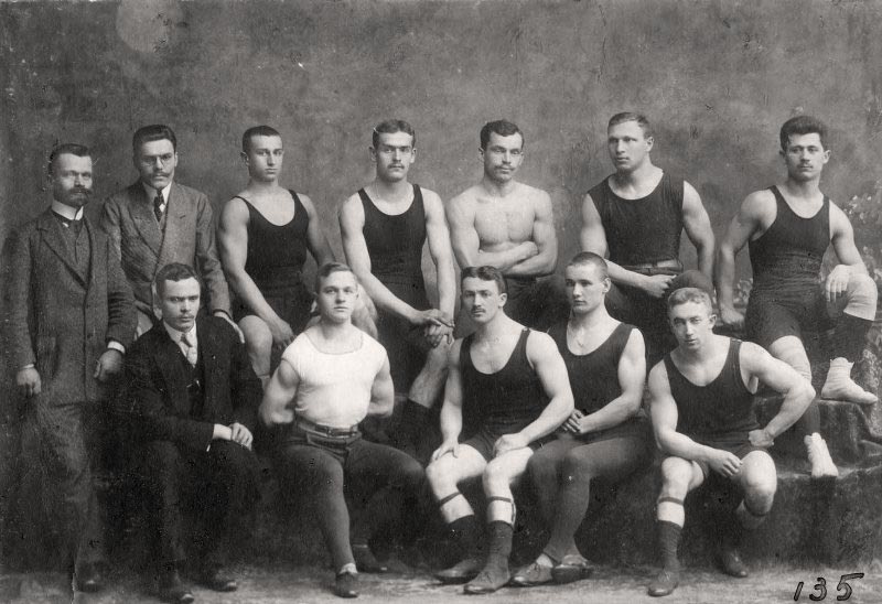 Змагання з дужання і двигання тягарів, організовані спортовим товариством «Україна» у Львові в рухівні «Сокола-Батька» 23–24 березня 1912 р. Зліва направо – 1-й ряд: Степан Гайдучок – суддя змагань, Володимир Криловський – член «Сокола-Батька», Олекса Гарасимів – член «Скали», Паращак – член «Скали», Богдан Гарасимів – член «Скали»; 2-й ряд: голова «Сокола-Батька» Іван Боберський та Казимир Врублевський – судді змагань, Миколаївський – член «Сокола-Батька», невідомий – член «Скали», Зенон Черевко – член «Сокола-Батька», Іван Маланчук – член «Сянової Чайки», Василь Остапчук – член «Сокола-Батька» і «України». З приватного архіву Степана Гайдучка (м. Львів).