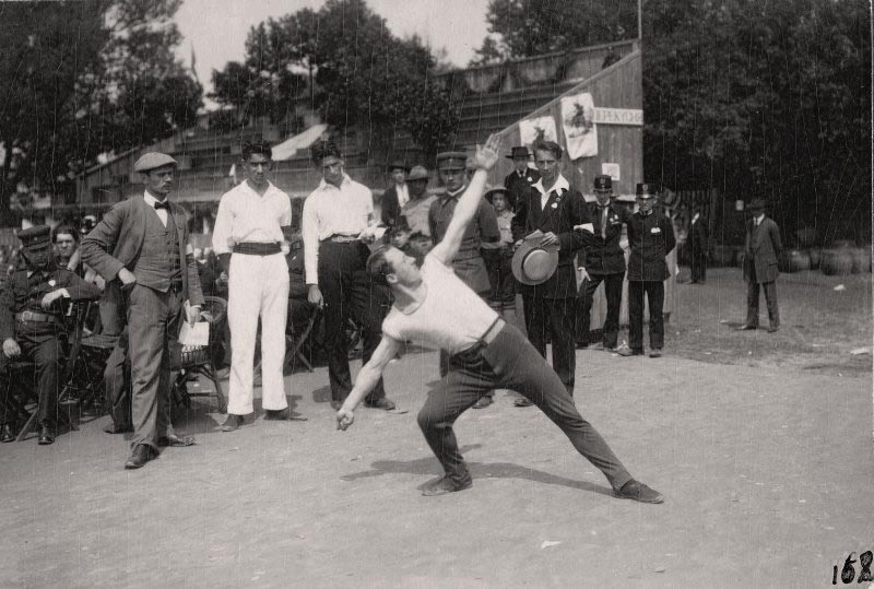 Руховик демонструє вихідне положення для метання ратищем (списом) у рамках ІІ-х Запорожських ігрищ. Перший зліва стоїть Степан Гайдучок. Львів, площа “Сокола-Батька”, 29 червня 1914 р. З приватного архіву Степана Гайдучка (м. Львів).