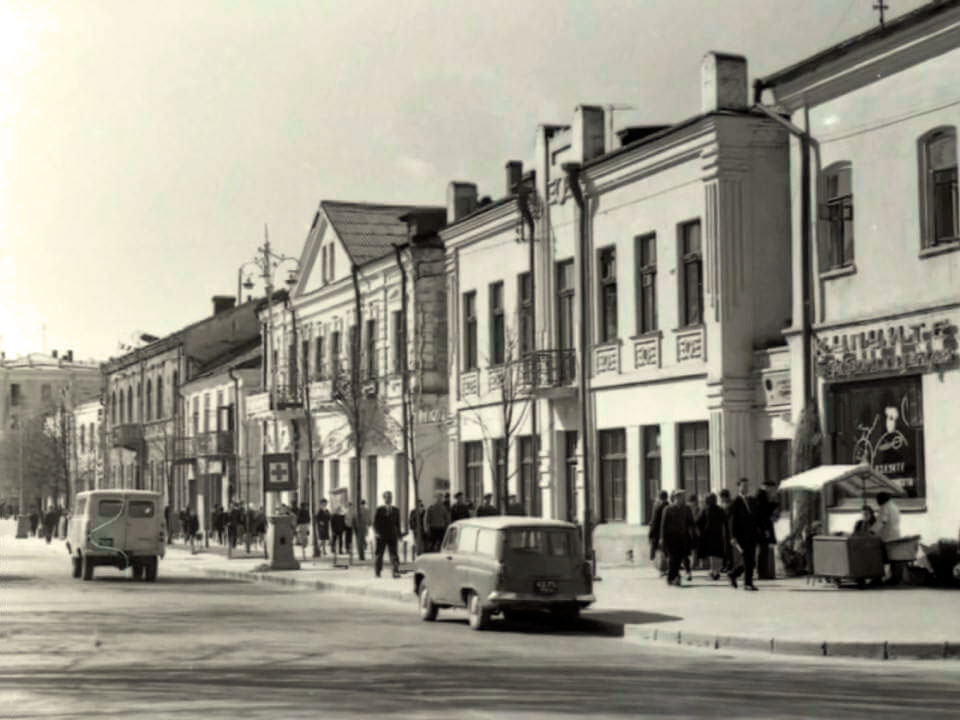 Вул. Ленінська (Соборна) в Рівному, перший будинок праворуч — колишній готель «Версаль», другий будинок — теперішній ТЦ «Прем’єр», за ним — заїзд на Поштову