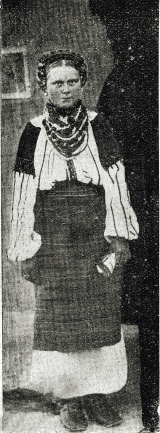 Поділля, пов. Заліщики, село Добровляни. Густо вишиті рукави сорочки, пазуха та обшивка. На голові вишита прикраса, подібно як у Яворівщині, повязана квітчата лента та над вухами ріжні затички. Обпинка заступає спідницю та фартух. На шиї кораликовий гердан та цілий ряд колірових кораликів. (Із видання "Österreich im Wort u. Bild" з Музею Н.Т.Ш. у Львові) 