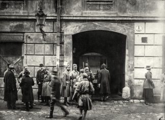 “Вхід до “Народного Дому” при вул. Театральній. Там містилася українська військова команда і там містився військовий комітет перед захопленням влади у Львові. З військового погляду незручне місце для керування боями” – Степан Гайдучок. Восьмий зліва у військовому однострої Іван Боберський. Львів, листопад 1918 р. З приватного архіву Степана Гайдучка (м. Львів).