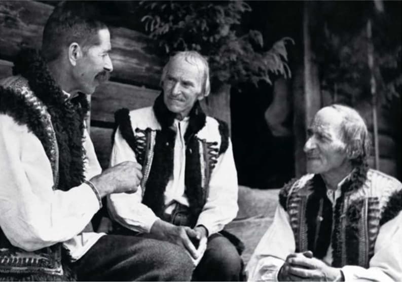 Гуцули зібралися для дружної бесіди на вулиці після церковної служби у Жаб'єму (тепер селище Верховина Івано-Франківської обл.). Два брати слухають розповідь товариша: " В одному стійлі був мій кінь, а в другому - велосипед американки"