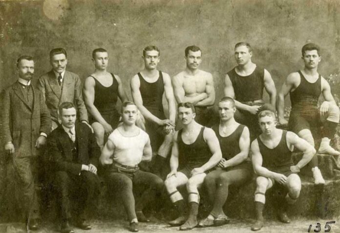 Змагання з дужання і двигання тягарів, організовані спортовим товариством «Україна» у Львові в рухівні «Сокола-Батька» 23–24 березня 1912 р. Зліва направо – 1-й ряд: Степан Гайдучок – суддя змагань, Володимир Криловський – член «Сокола-Батька», Олекса Гарасимів – член «Скали», Паращак – член «Скали», Богдан Гарасимів – член «Скали»; 2-й ряд: голова «Сокола-Батька» Іван Боберський та Казимир Врублевський – судді змагань, Миколаївський – член «Сокола-Батька», Невідомий – член «Скали», Зенон Черевко – член «Сокола-Батька», Іван Маланчук – член «Сянової Чайки», Василь Остапчук – член «Сокола-Батька» і «України». З приватного архіву Степана Гайдучка (м. Львів).