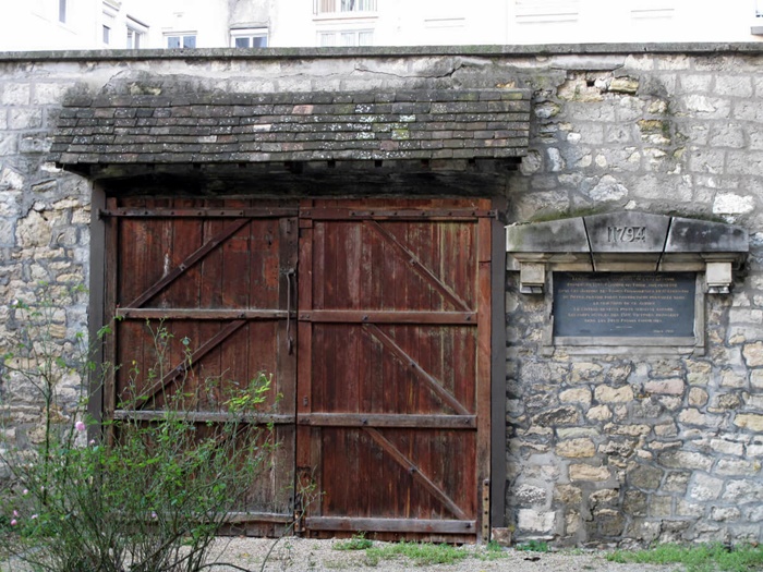 Ворота, через які завозили тіла страчених до монастирського саду. Праворуч табличка, яка розповідає про ті події. Французи бережуть своє минуле