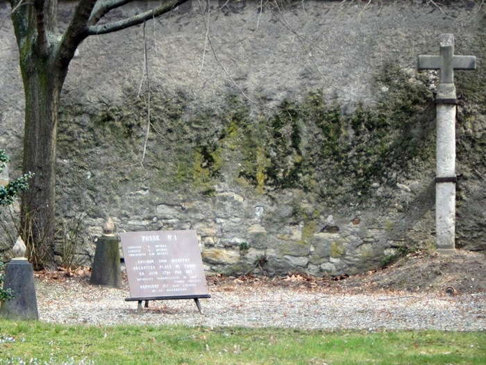 Одна з ям, посипана гравієм, у глибині двору під парканом 
