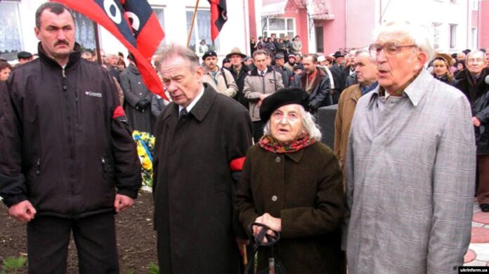 Під час відкриття пам’ятника головнокомандувачу УПА генералу Роману Шухевичу в селі Княгиничі на Івано-Франківщині, 13 листопада 2005 року. На фото: його син Юрій Шухевич (другий ліворуч) та колишні зв’язкові УПА Ольга Ільків і Любомир Полюга. У селі Княгиничах Роман Шухевич перебував із жовтня 1946-го по вересень 1947 року