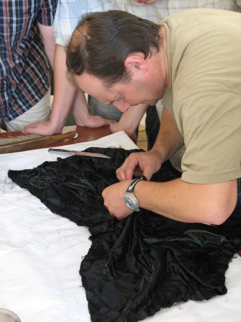 Ярослав Онищук розвертає віднайдену частину прапора пластового куреня “Лісові Чорти”. 7 червня 2007 р.