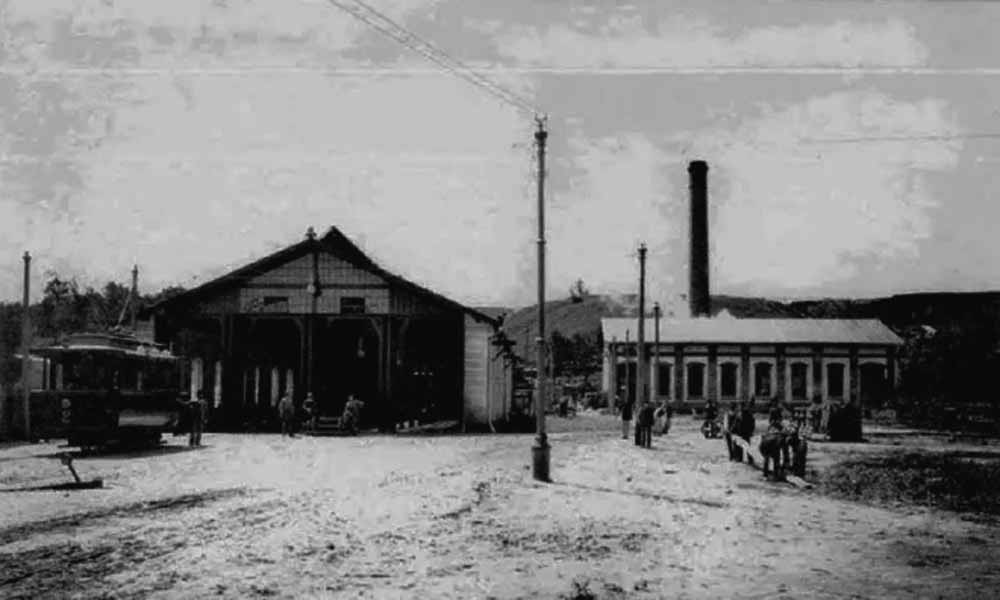 Перше депо електричного трамвая (на передньому плані ліворуч) та міська електростанція постійного струму (на задньому плані праворуч). Світлина 1894 р.