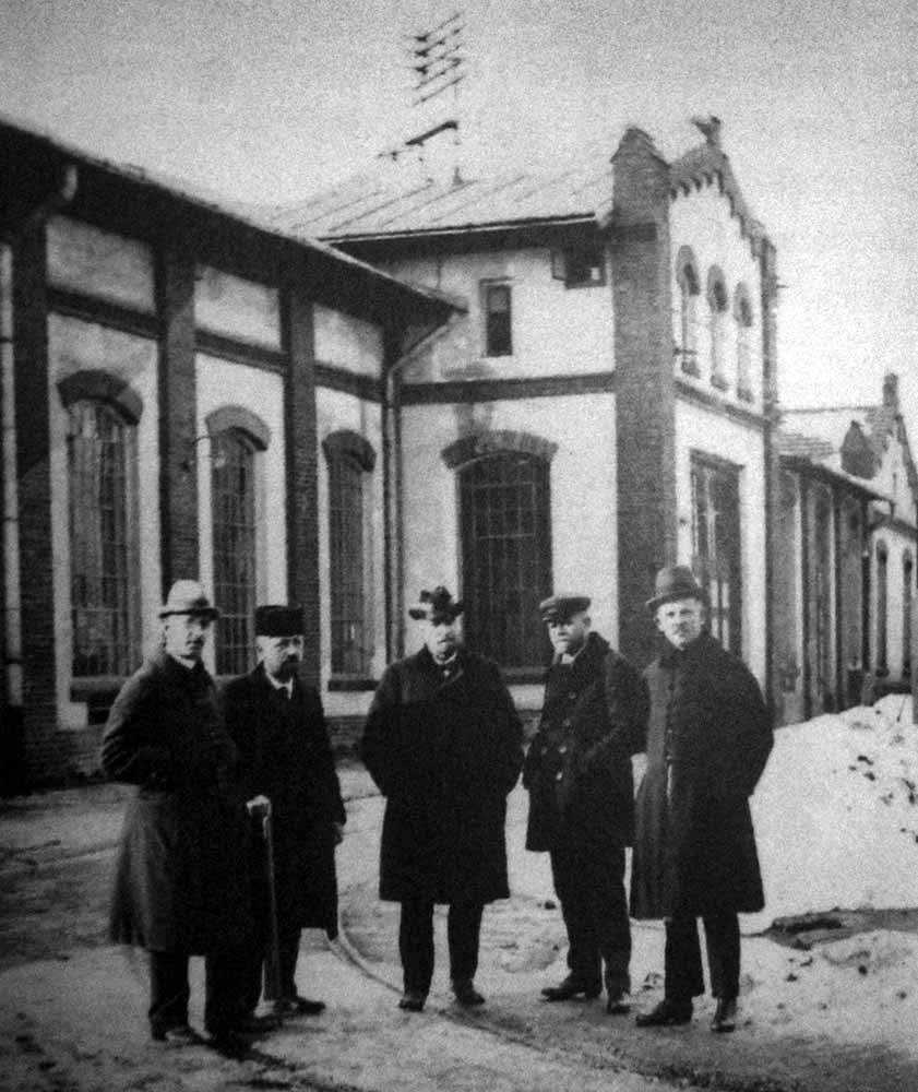 Йозеф Томицький і працівники Міських закладів електричних на фоні міської електростанції постійного струму. Світлина початку ХХ ст