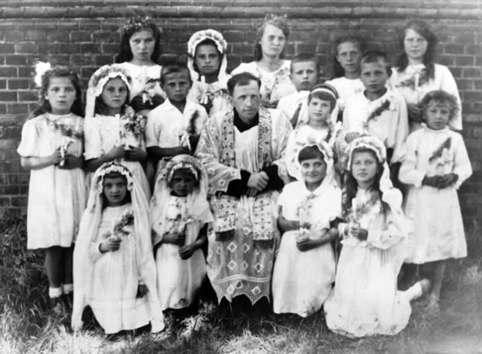 Перше причастя, отець Серафим з дітьми біля стін костелу Св. Антонія у Рівному, 1946 рік