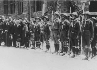 Дрогобицькі пластуни під час посвячення гімназії «Рідної школи», 1928 р. На церемонії присутні опікун Пласту в Дрогобичі о. Степан Венгринович, директор гімназії Володимир Кузьмович, сктм. Михайло Іваненко, кошовий Дрогобицького коша Петро Веприк, гості зі Львова Верховний Отаман Северин Левицький, ст. пл. Марія Охримович, ст. пл. Тарас Дурбак. Світлина опублікована: Сова А. Печатки 18 пластового куреня імени Івана Франка у Дрогобичі, 1920-ті рр. // Пластовий шлях. Журнал пластової думки та інформації. – Львів, 2023. – Чис. 3 (211). – С. 40–41.