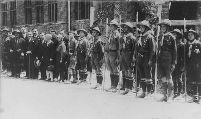 Дрогобицькі пластуни під час посвячення гімназії «Рідної школи», 1928 р. На церемонії присутні опікун Пласту в Дрогобичі о. Степан Венгринович, директор гімназії Володимир Кузьмович, сктм. Михайло Іваненко, кошовий Дрогобицького коша Петро Веприк, гості зі Львова Верховний Отаман Северин Левицький, ст. пл. Марія Охримович, ст. пл. Тарас Дурбак. Світлина опублікована: Сова А. Печатки 18 пластового куреня імени Івана Франка у Дрогобичі, 1920-ті рр. // Пластовий шлях. Журнал пластової думки та інформації. – Львів, 2023. – Чис. 3 (211). – С. 40–41.