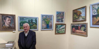 Святослав Мартинюк на тлі експозиції виставки