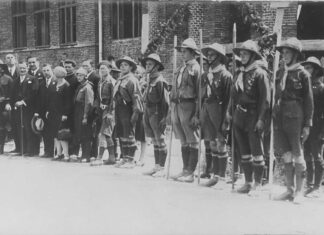 Дрогобицькі пластуни під час посвячення гімназії «Рідної школи», 1928 р. На церемонії присутні опікун Пласту в Дрогобичі о. Степан Венгринович, директор гімназії Володимир Кузьмович, сктм. Михайло Іваненко, кошовий Дрогобицького коша Петро Веприк, гості зі Львова Верховний Отаман Северин Левицький, ст. пл. Марія Охримович, ст. пл. Тарас Дурбак. Світлина опублікована: Сова А. Печатки 18 пластового куреня імени Івана Франка у Дрогобичі, 1920-ті рр. // Пластовий шлях. Журнал пластової думки та інформації. – Львів, 2023. – Чис. 3 (211). – С. 40–41.